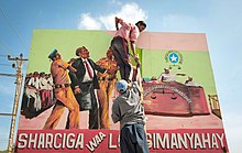 Một bức tranh tường với biển quảng cáo có nội dung "Trước pháp luật, mọi người đều bình đẳng" được một nhóm nghệ sĩ đặt dọc theo con đường dẫn đến Sân bay Quốc tế Mogadishu